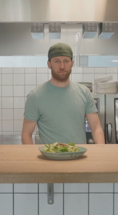 The chef in the kitchen with a plate of food