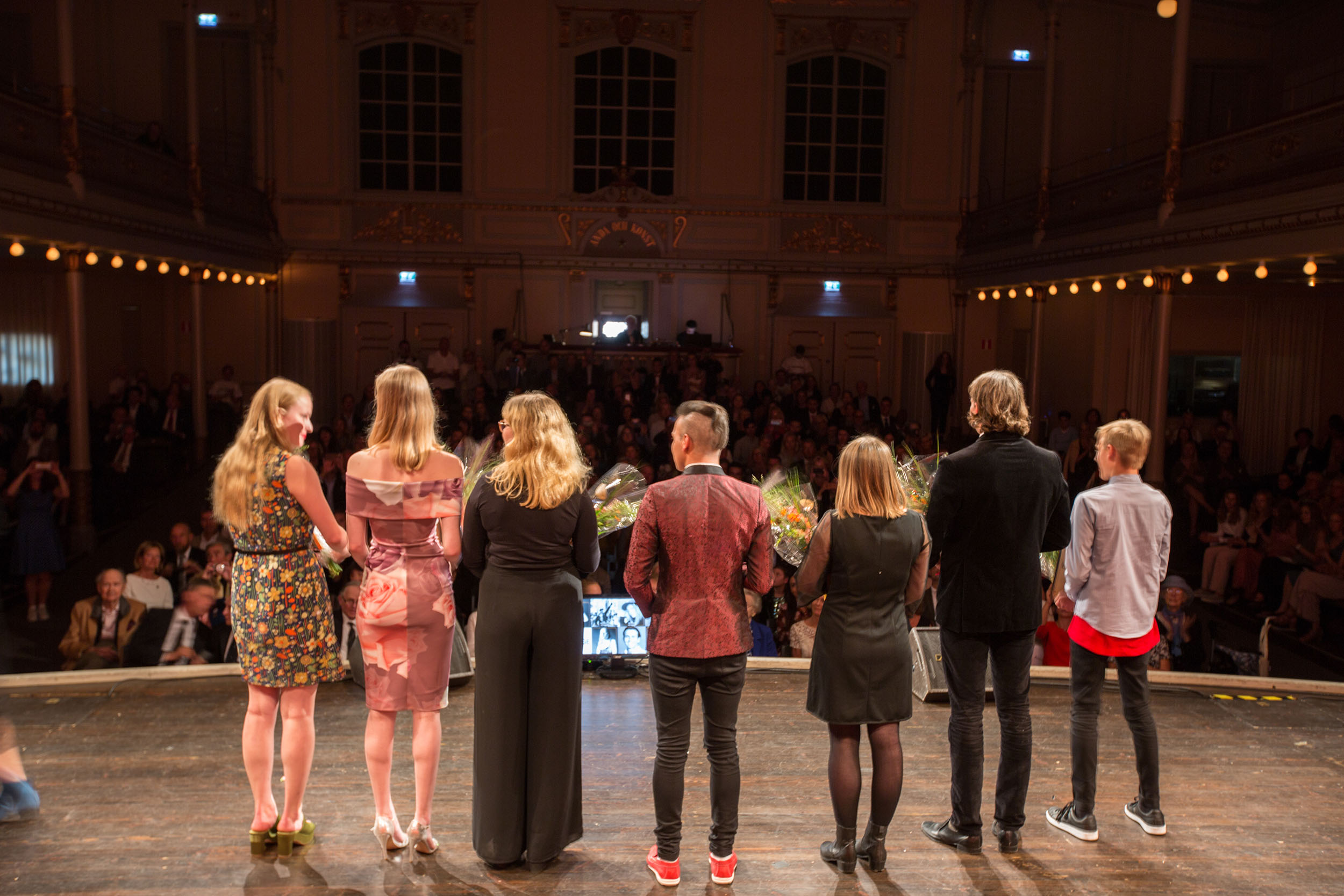 A group of young people recieving an award on stage.