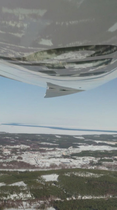 A northern landscape mirrored on the wing of a plane.