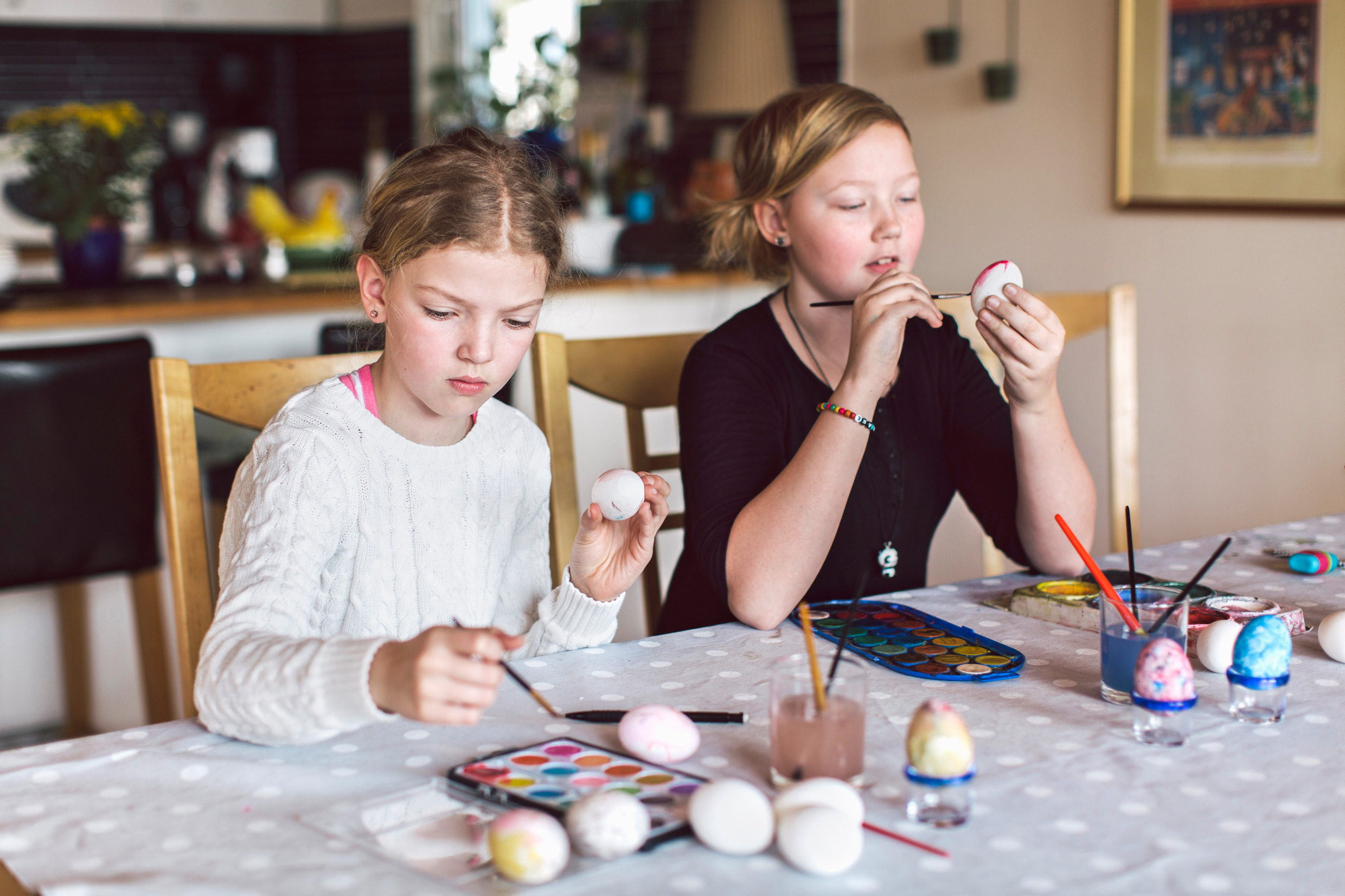 Two children painting eggs.