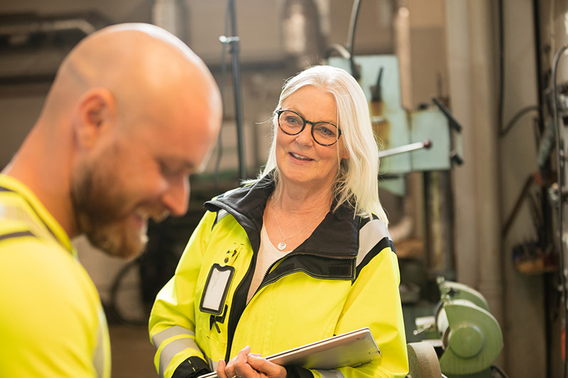 An woman working in industry talking to her male coworker