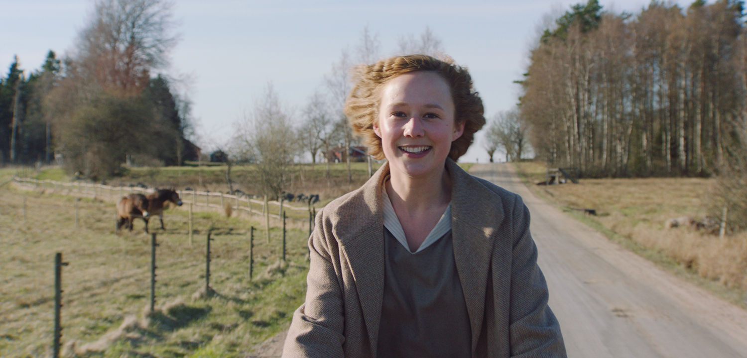 A young Astrid riding a bike.