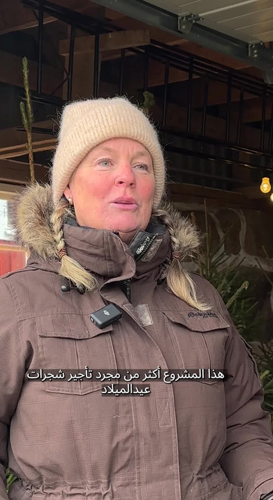 A woman renting out Christmas trees.