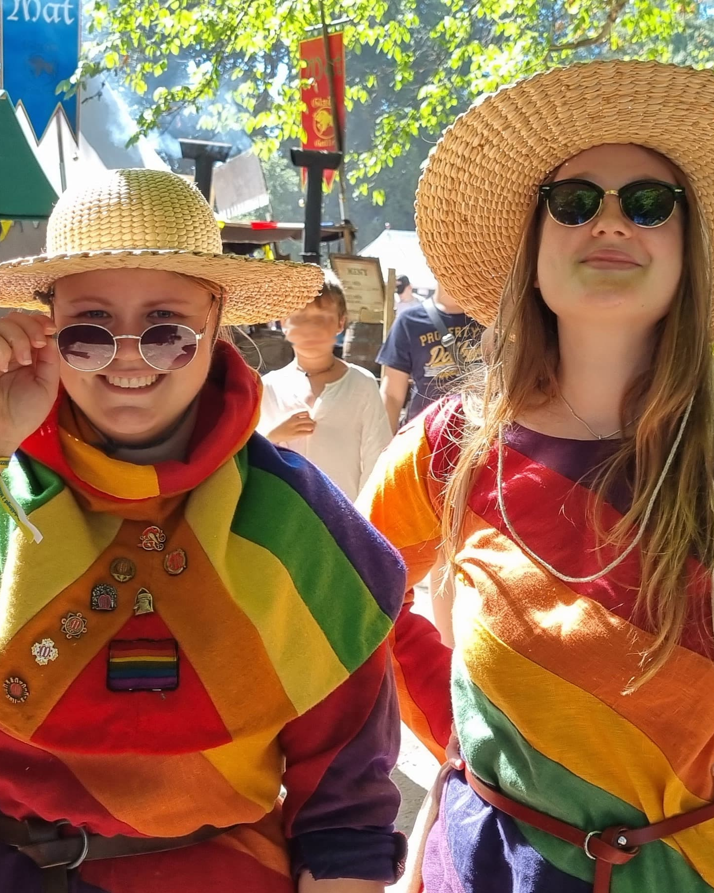 Two persons in mediieval inspired rainbow clothing.